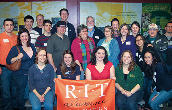 People gathered for picture with RIT flag