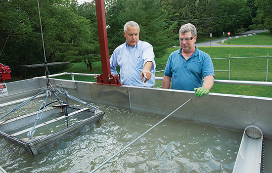  two people looking at water filtration process.