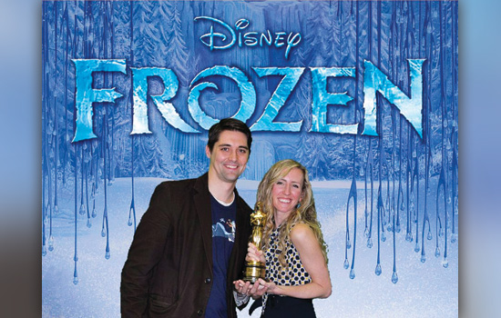 People posing in front of Disney Frozen sign