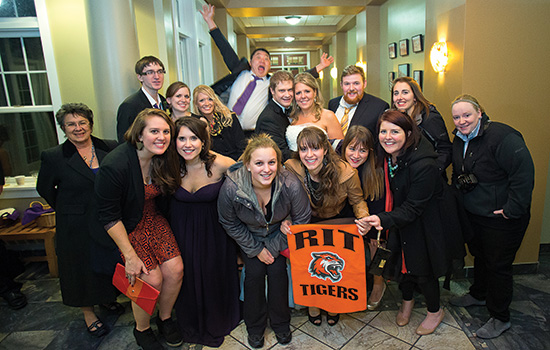 People posing with banner at event