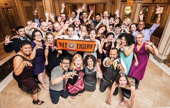 People posing with banner at event