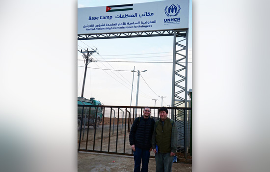 Two people posing in front of entry way