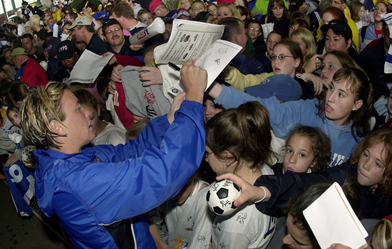 Person signing papers in crowd