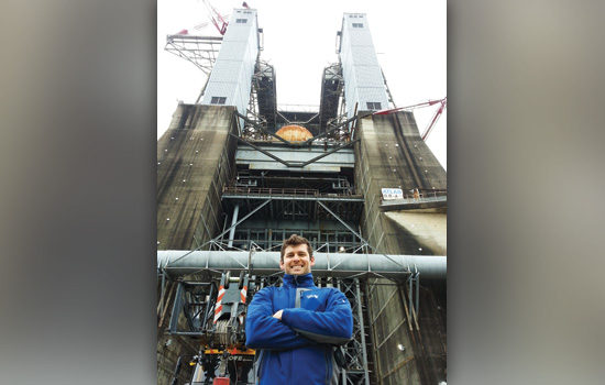 Jason Grow standing in front of the space launch system.