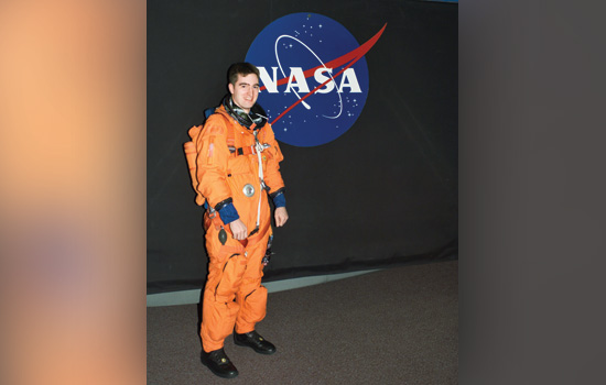 paul Reichert in space suit standing in front of nasa