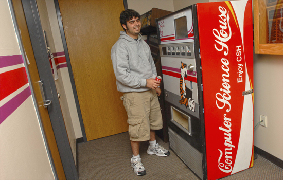 college student standing in front of a custom Coke machine.