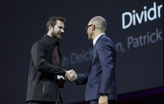 two people shaking hands on a stage.
