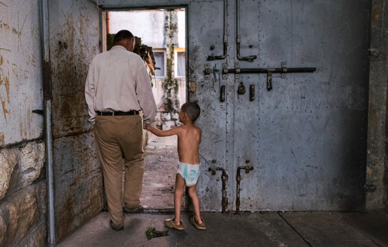 Person walking with kid through entryway