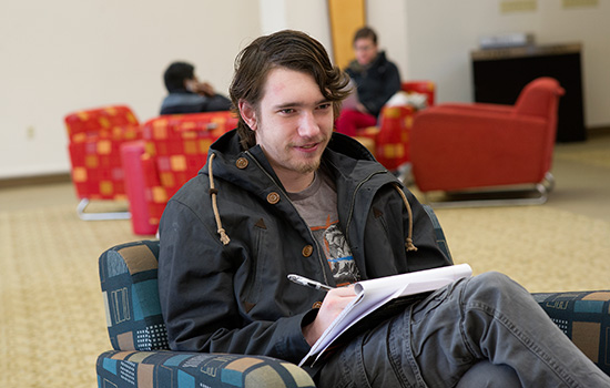 Student taking notes on chair