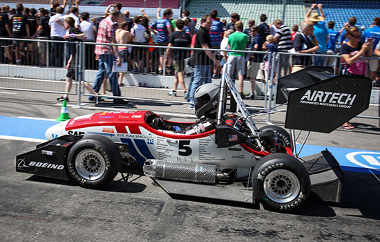Person driving formula car on race track