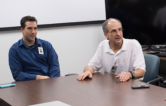 Student and Astronaut sitting at conference table