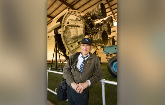 Person posing next to rocket engine