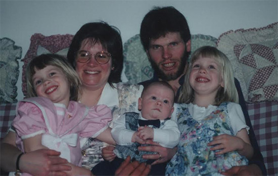 a family photo with two adults and three kids.