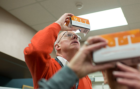 RIT President looking through goggles