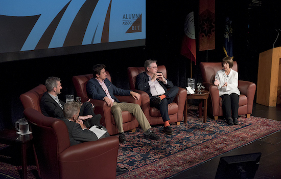 People speaking on stage at event