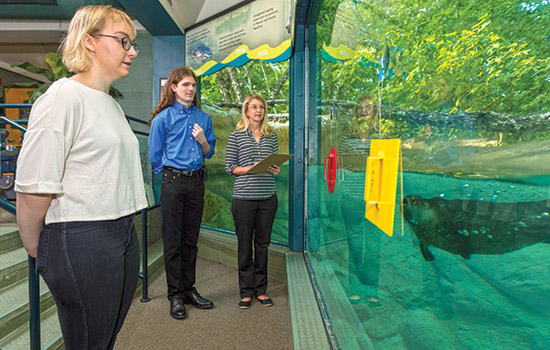 Three professors looking at aquarium