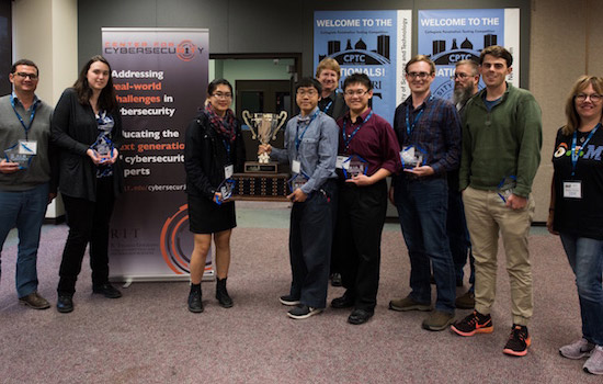 group of college students holding a trophy.