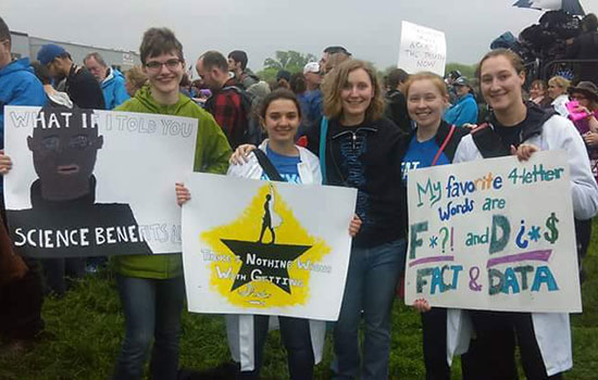 students holding up signs for the march for science.