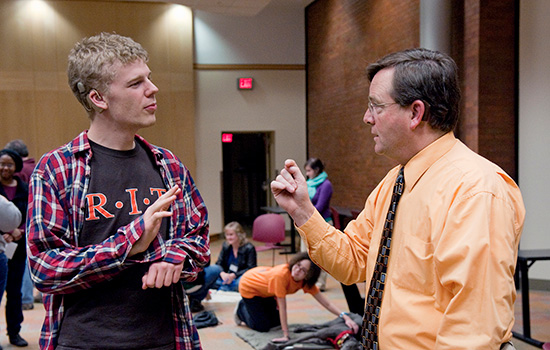 NTID president signing with a former student.