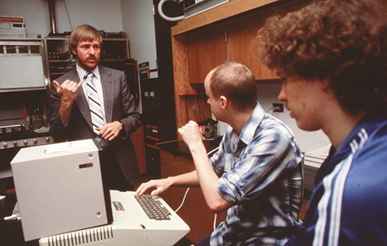  Harry Lang signing to students in a lab.