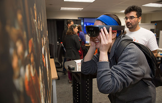 A person wearing AR goggles, looking at artwork.