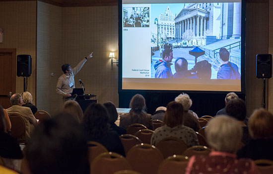 people in the audience looking at the projector screen.