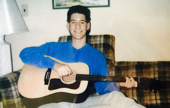 image of Patrick Lynch with guitar in lap.