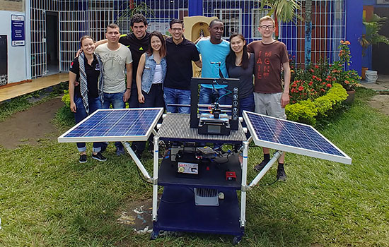 Team poses together around their solar powered 3D printer.