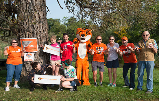 group of volunteers posing outside with a Tiger mascot.