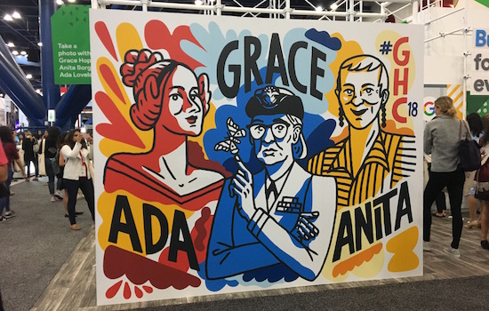  three women painted on a sign for grace hopper celebration. from left to right, ada painted in red, grace painted in blue, and anita painted in yellow.