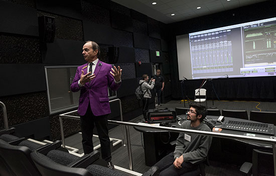  person standing in front of a screen showing sound mixing.