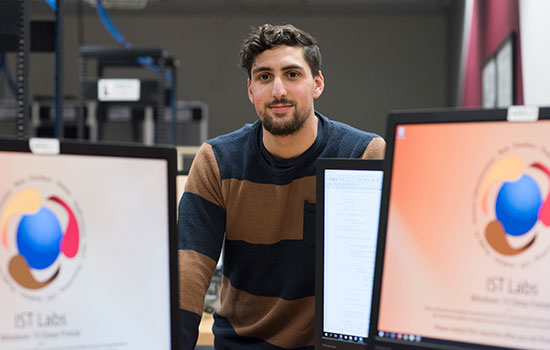 Brennan Jackson poses with computer screens around him.