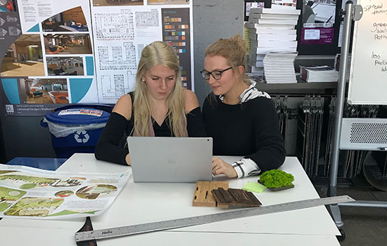 two people looking at a laptop computer.