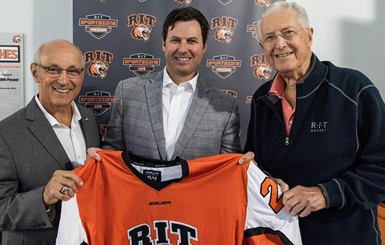  three people posing for photo while holding RIT hockey jersey.