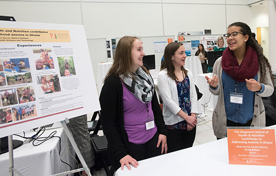  three students share research on anemia in Ghana with a poster.